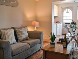 a living room with a couch and a table at Sweet Pea Cottage- 28322 in Holt