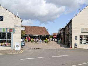 an empty street in a small town with buildings at Sweet Pea Cottage- 28322 in Holt