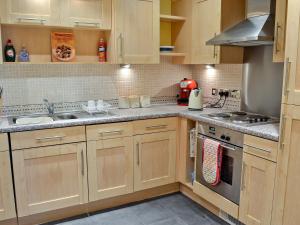 a kitchen with wooden cabinets and a stove top oven at Martin's Court in York