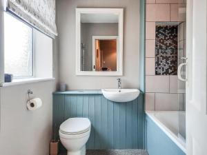 a bathroom with a toilet and a sink and a tub at Coastguard Cottage in Fleetwood