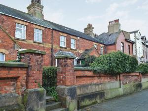 a brick building with a brick fence and a street at Coastguard Cottage in Fleetwood