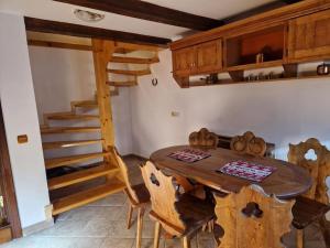 錫納亞的住宿－Casa Botiza - Cătun，一间带木桌和木楼梯的用餐室