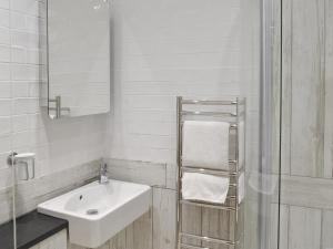 a white bathroom with a sink and a mirror at Haven Cottage - 28269 in Port Isaac
