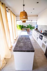 uma cozinha com uma grande ilha no meio de uma sala em Casa nova completa a poucos passos da Praia do Mutà em Porto Seguro