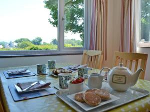 a table with a tea kettle and pastries on it at Didfa - 27912 in Llangoed