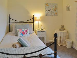 a bedroom with a bed and a table with a lamp at Didfa - 27912 in Llangoed
