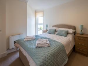 a bedroom with a bed with two towels on it at Culver View in Shanklin