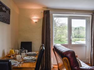 a dining room with a table and a window at Robin Cottage in Llandeilo