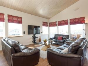a living room with two leather couches and a tv at Broad Reach - 28121 in Fritton
