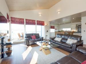 a living room with leather couches and a table at Broad Reach - 28121 in Fritton