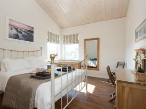 a bedroom with a bed and a table in it at Broad Reach - 28121 in Fritton
