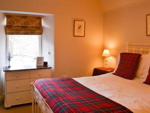 a bedroom with a bed and a window at Einich in Newtonmore