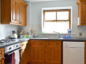 a kitchen with wooden cabinets and a sink and a window at Big Barn - 16439 in Huntington