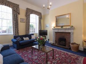a living room with a couch and a fireplace at The Old Butlers House in Cley next the Sea
