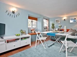 un soggiorno con tavolo, sedie e divano di Sea Glass Cottage a Dawlish