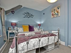 una camera con letto e parete blu di Sea Glass Cottage a Dawlish