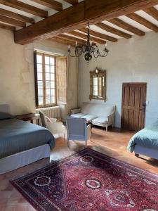 a bedroom with two beds and a couch and a rug at Clos Saint Léonard in Durtal
