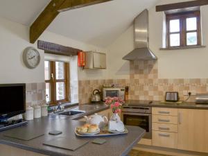 a kitchen with a table with a plate of food on it at Orchard Close -17380 in Kilkhampton
