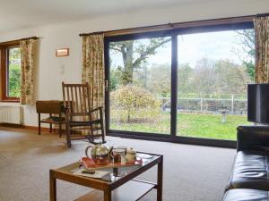 a living room with a large sliding glass door at Kingfisher Cottage in Pitlochry