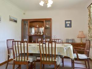 a dining room with a table and four chairs at Kingfisher Cottage in Pitlochry