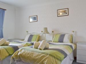 two beds sitting next to each other in a bedroom at Kingfisher Cottage in Pitlochry