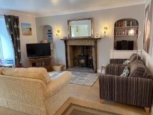 a living room with two couches and a fireplace at Dolphin Cottage in Nairn