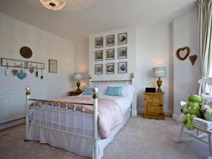 a bedroom with a bed and two lamps and a chair at Kerensa in Looe