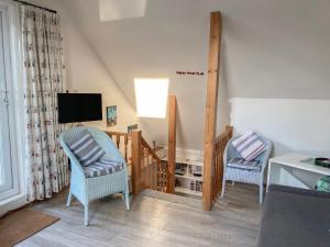 a living room with two chairs and a television at The Bow in Middleton-on-Sea