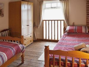 フランボローにあるPeregrine Cottageのベッドルーム1室(ベッド2台、窓付)