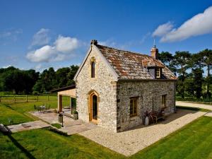 una pequeña casa de piedra en medio de un campo en The Chapel - Chard en Wambrook