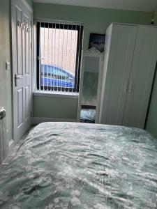 a bedroom with a large bed and a window at 44 Inaclete Road in Stornoway