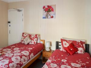 1 Schlafzimmer mit 2 Betten mit roten Bettdecken in der Unterkunft Mill View House in Scarborough