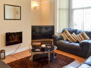 ein Wohnzimmer mit einem Sofa und einem TV in der Unterkunft Mill View House in Scarborough