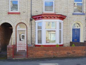 ceglany dom z czerwoną bramą i niebieskimi drzwiami w obiekcie Mill View House w Scarborough