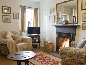 a living room with a couch and a fireplace at Bryn Tirion in Llantrisant