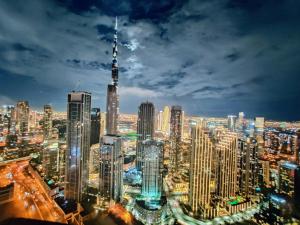 a view of a large city at night at Paramount Hotel Midtown Flat with Burj Khalifa View in Dubai