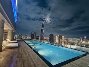 a swimming pool on the roof of a building with a city skyline at Paramount Hotel Midtown Flat with Burj Khalifa View in Dubai