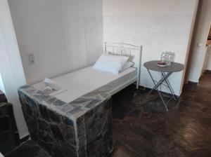 Kea Island II في Korissia: غرفة صغيرة بها سرير وطاولة