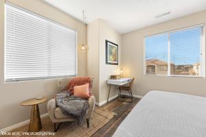 um quarto com uma cama, uma cadeira e 2 janelas em Sparkling Springs by J & Amy BL90802 em Mesquite