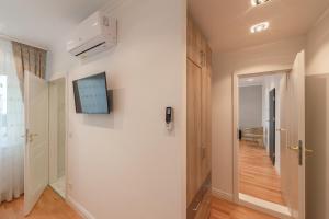 korytarz z białą ścianą z telewizorem w obiekcie Cool Boutique Apartments - Leopoldstadt w Wiedniu