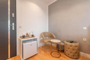 een kamer met een stoel, een kruk en een tafel bij Cool Boutique Apartments - Leopoldstadt in Wenen