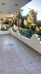 a balcony with a white railing and a tile floor at 150ευρώ η μέρα in Oropós