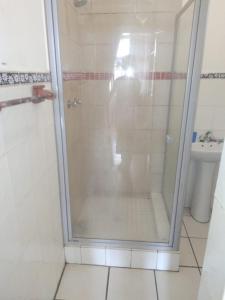 a shower with a glass door in a bathroom at Alo guesthouse in Pietermaritzburg