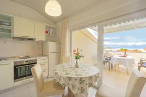 a kitchen and dining room with a table and chairs at Erica perfect central location near beach in Novalja +24 photos