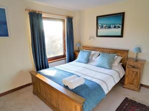 a bedroom with a large bed with a window at Rosmuire in Rhu