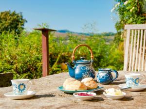 a table with a blue tea pot and plates of food at Rosmuire in Rhu