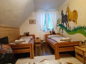 two beds in a room with a mural of a horse on the wall at Jízdárna Malenovice in Malenovice