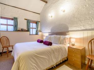um quarto com uma cama branca com duas almofadas em The Old Stables em York
