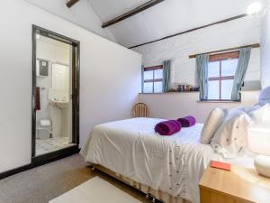 ヨークにあるThe Old Stablesのベッドルーム1室(紫色の枕が付いたベッド1台付)