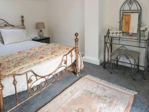 a bedroom with a bed and a table and a mirror at Honeymead Cottage in Wick